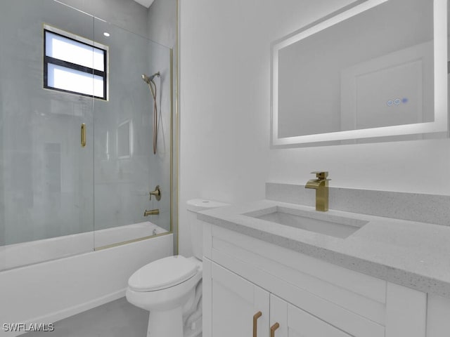 full bathroom with bath / shower combo with glass door, vanity, and toilet