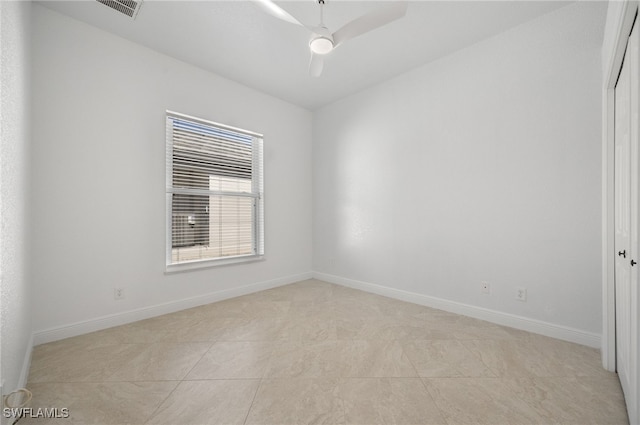 tiled spare room with ceiling fan