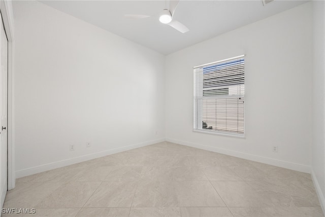 tiled empty room featuring ceiling fan