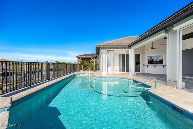 view of swimming pool featuring a gazebo, ceiling fan, and a patio area