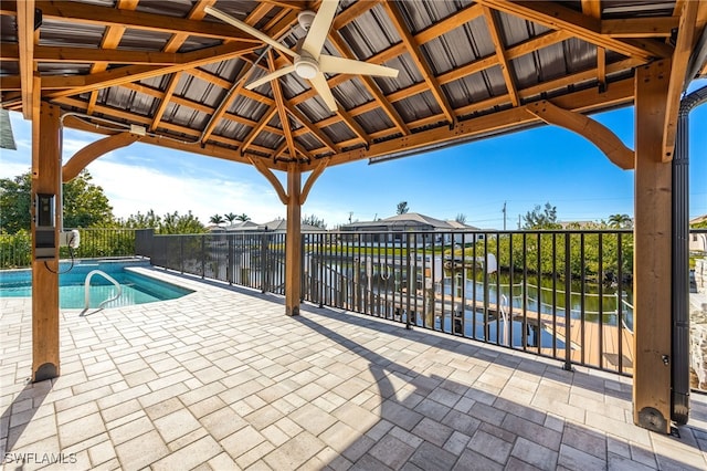 view of pool featuring a gazebo, ceiling fan, and a water view