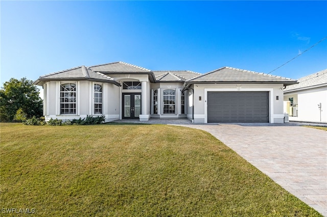 view of front facade featuring a front lawn, a garage, and french doors