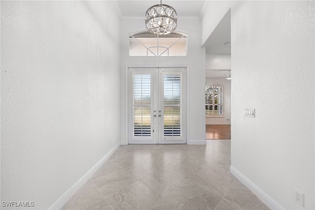 entryway with french doors, crown molding, and a notable chandelier