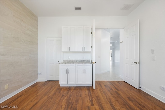 kitchen featuring white cabinetry, light stone countertops, and dark hardwood / wood-style floors