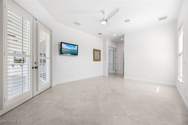 empty room with ceiling fan, a wealth of natural light, and french doors