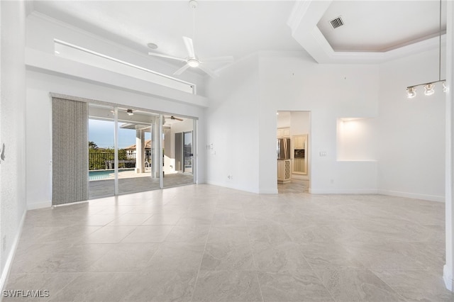 unfurnished room with ceiling fan, a towering ceiling, and crown molding