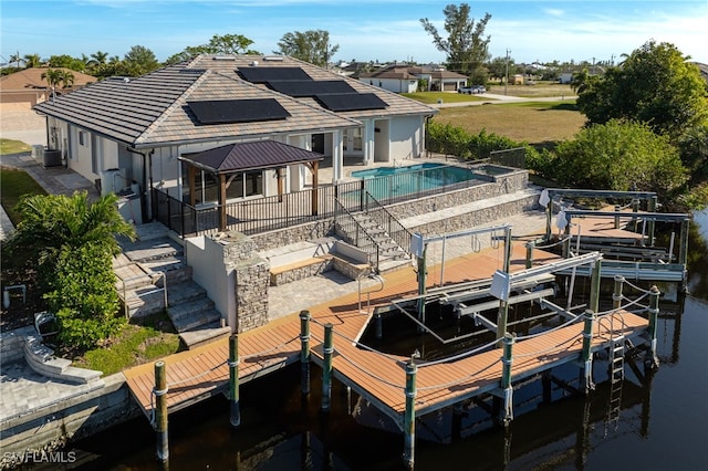 back of property with a patio area, central AC unit, and solar panels