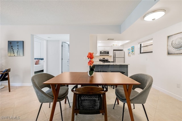 dining room with light tile patterned floors and a textured ceiling