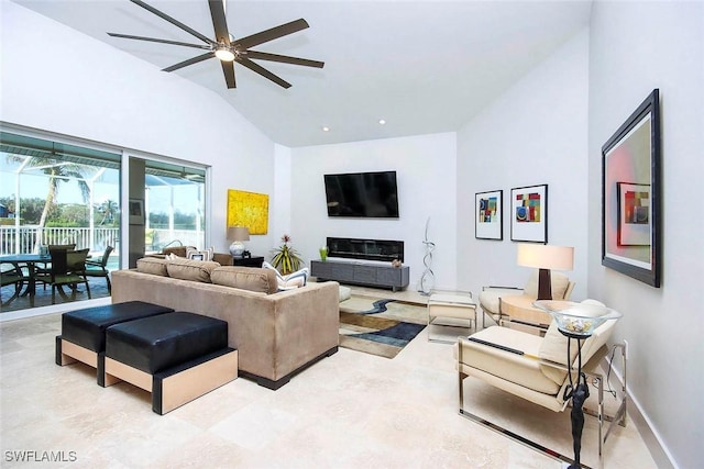 living room featuring ceiling fan, a fireplace, and high vaulted ceiling