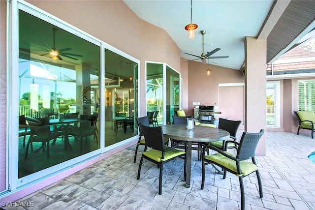 sunroom with ceiling fan and vaulted ceiling