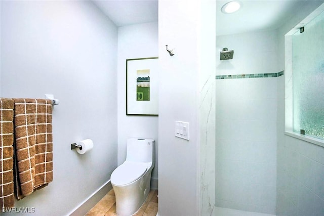 bathroom with a tile shower, tile patterned floors, and toilet