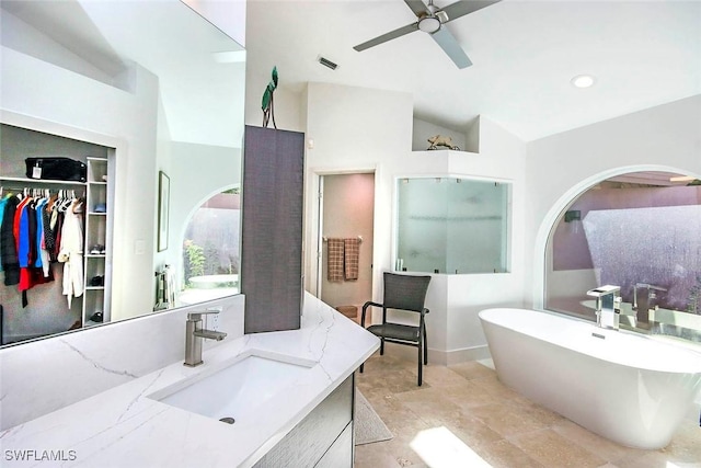 bathroom with vanity, ceiling fan, independent shower and bath, and vaulted ceiling