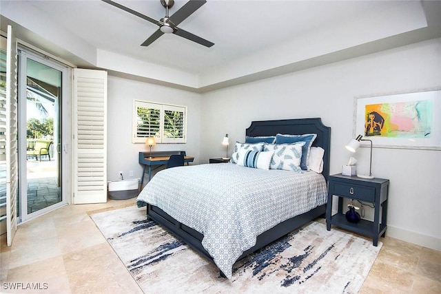 bedroom with a raised ceiling, multiple windows, ceiling fan, and access to exterior