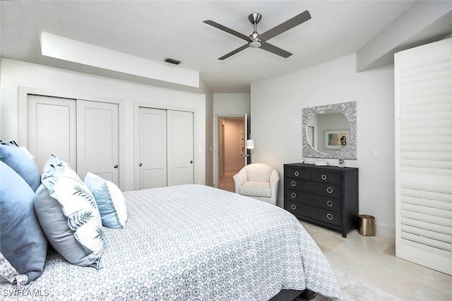 bedroom with ceiling fan and two closets