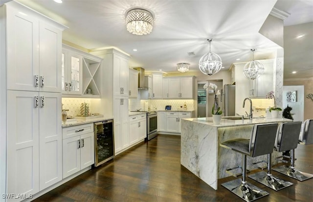 kitchen featuring white cabinetry, light stone countertops, beverage cooler, and appliances with stainless steel finishes