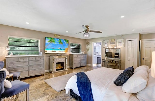 bedroom with ceiling fan, a premium fireplace, and ensuite bathroom