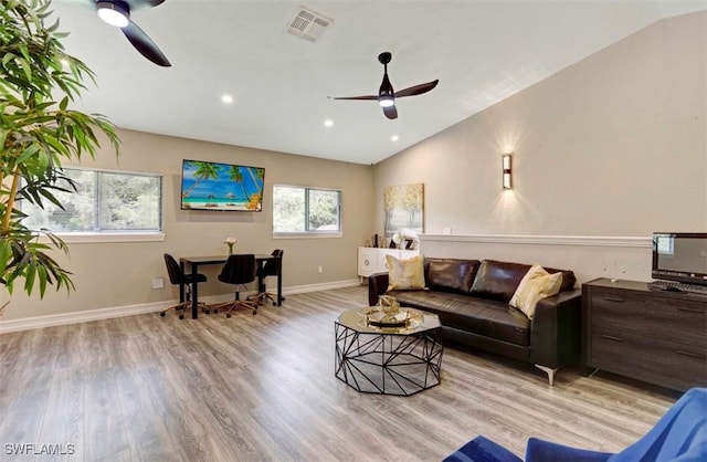 living room featuring ceiling fan, light hardwood / wood-style floors, and lofted ceiling