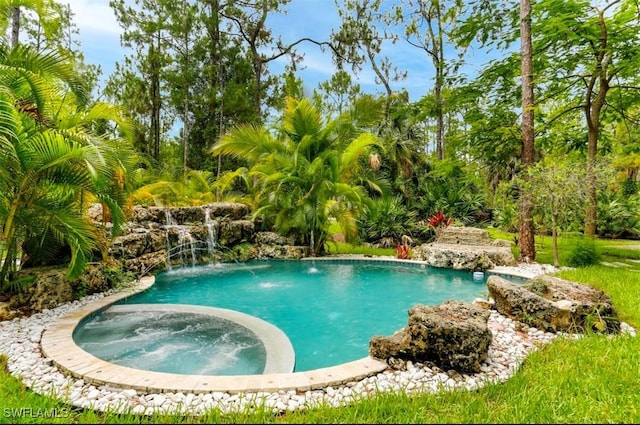 view of swimming pool featuring an in ground hot tub