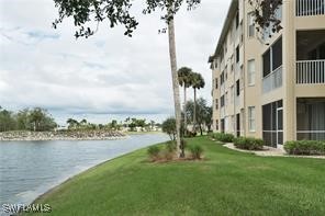 view of property's community with a lawn and a water view