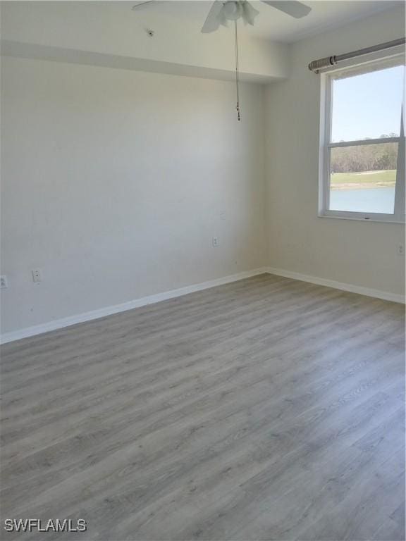 empty room with a ceiling fan, baseboards, and wood finished floors