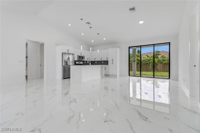 unfurnished living room with sink and high vaulted ceiling