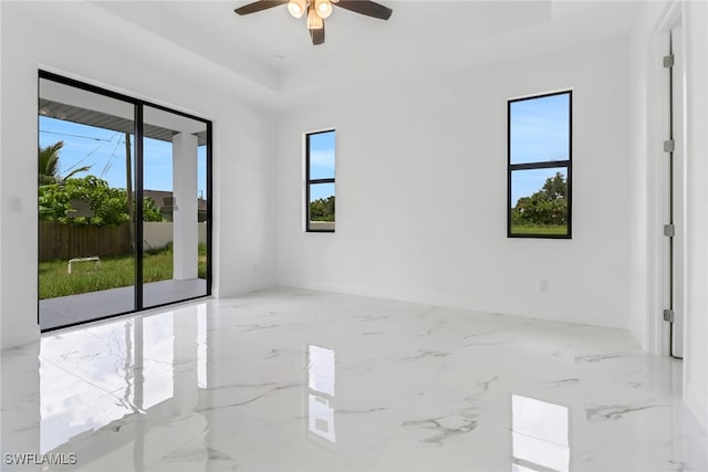 unfurnished room with ceiling fan and a healthy amount of sunlight