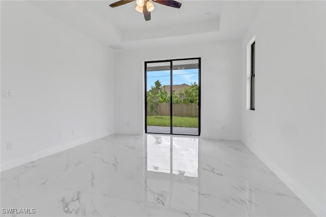 empty room with a raised ceiling and ceiling fan