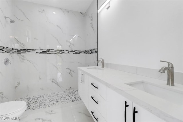 bathroom featuring vanity, toilet, and tiled shower