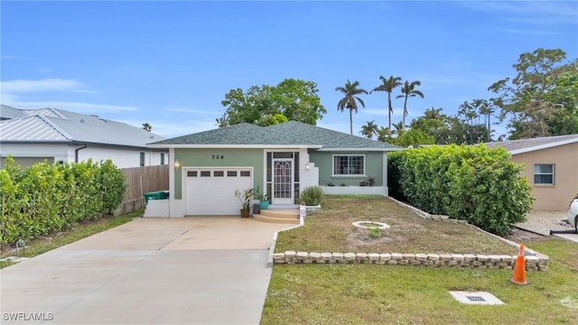 view of front facade with an attached garage, fence, concrete driveway, and stucco siding