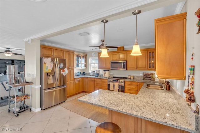 kitchen featuring crown molding, light tile patterned floors, appliances with stainless steel finishes, light stone countertops, and a peninsula