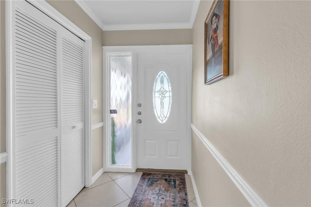 entryway featuring ornamental molding, light tile patterned flooring, and baseboards