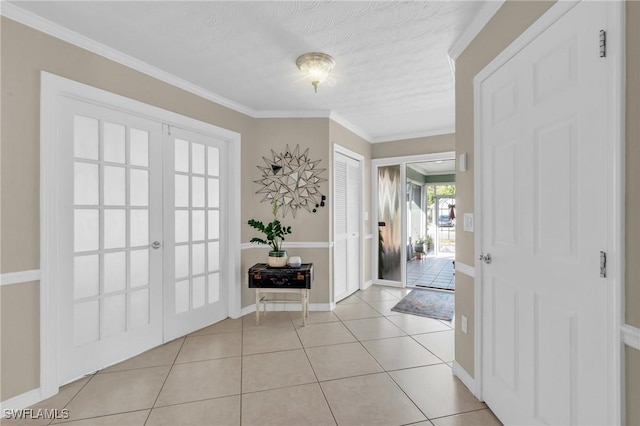 foyer featuring ornamental molding, french doors, baseboards, and light tile patterned floors