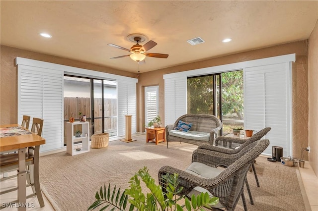 sunroom with a healthy amount of sunlight, visible vents, and ceiling fan