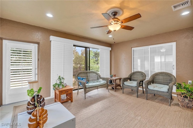 living area featuring recessed lighting, visible vents, a textured wall, and ceiling fan