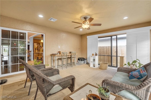 living area with visible vents, a textured wall, ceiling fan, carpet floors, and recessed lighting