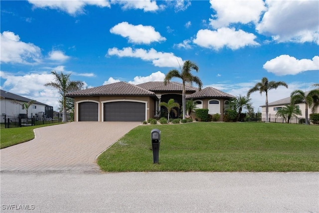 mediterranean / spanish house with a garage and a front lawn