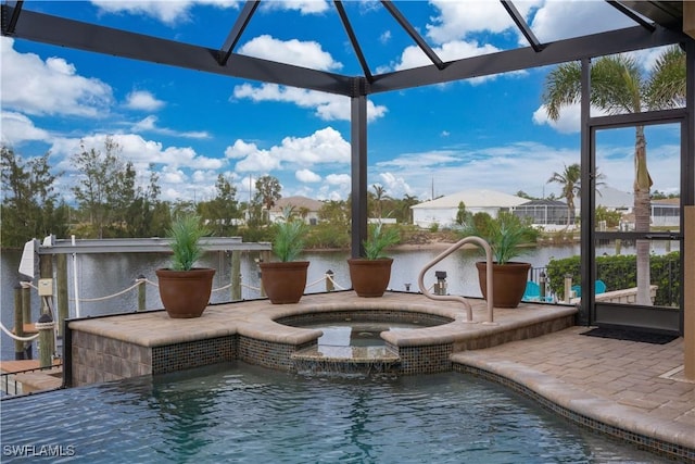 view of pool with an in ground hot tub, a water view, and a patio area