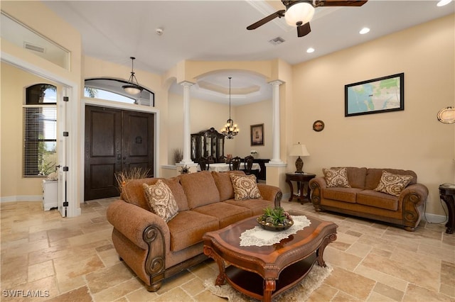 living room featuring ceiling fan with notable chandelier and decorative columns