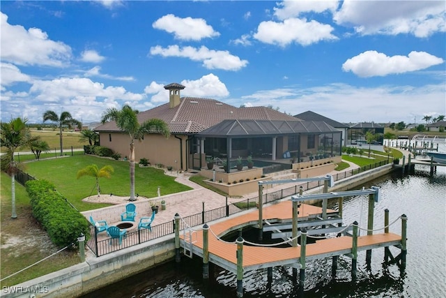 dock area featuring a lanai, a yard, and a water view