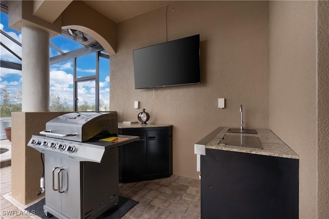 view of patio / terrace featuring a grill, a lanai, and sink