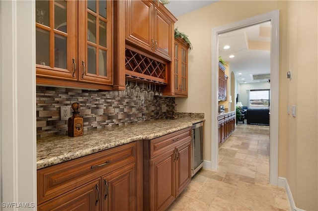 bar featuring light stone countertops, backsplash, and wine cooler