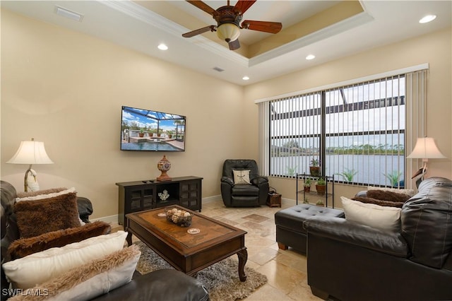 living room with ceiling fan, crown molding, and a tray ceiling