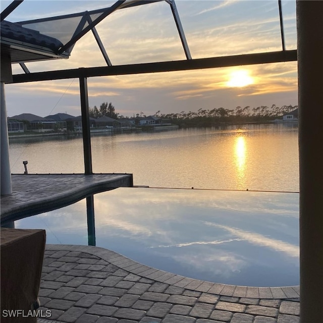 dock area with a lanai and a water view