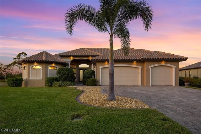 mediterranean / spanish-style house with a yard and a garage