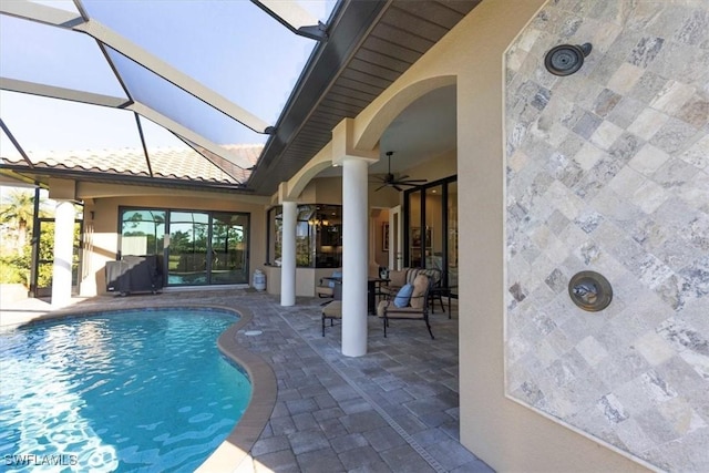 view of pool featuring ceiling fan, a patio, and glass enclosure