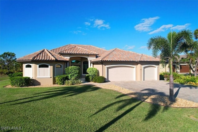 mediterranean / spanish-style house featuring a garage and a front lawn