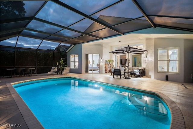 pool at dusk with outdoor lounge area, a patio area, and a lanai