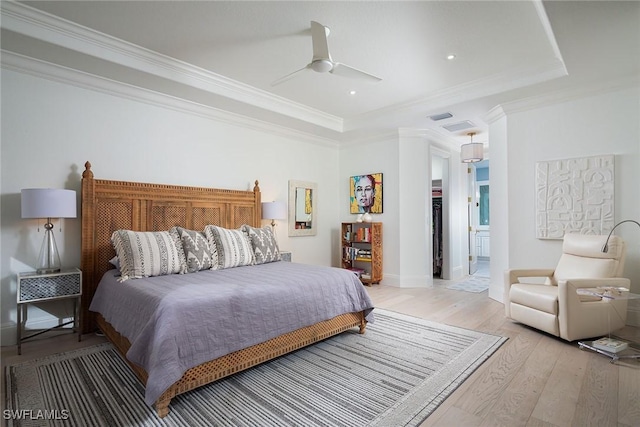 bedroom featuring light wood-type flooring, ceiling fan, crown molding, and connected bathroom