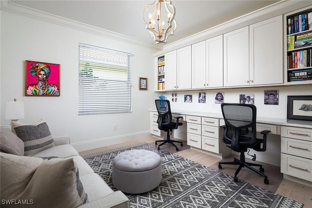 office space featuring a chandelier, crown molding, built in desk, and light wood-type flooring