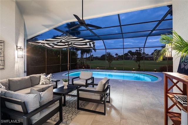 pool at dusk featuring an outdoor living space, a lanai, and a patio